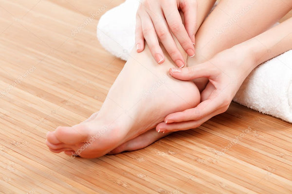 Female feet and hands with a white rolled towel