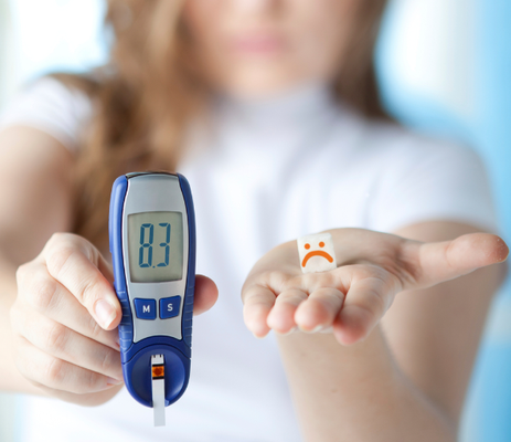 A woman holding her glucose monitor